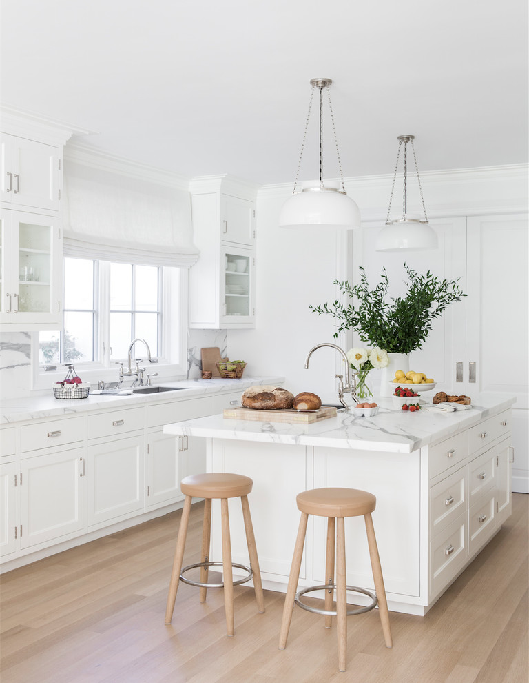 This is an example of a transitional kitchen in New York with an undermount sink, shaker cabinets, white cabinets, white appliances, light hardwood floors, with island and beige floor.
