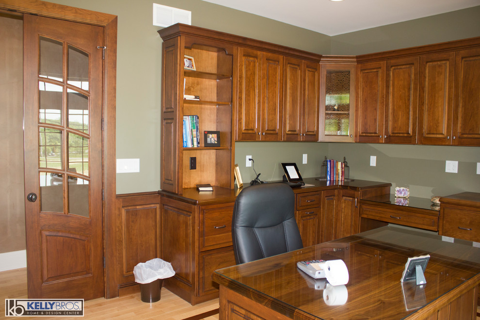 Photo of a traditional study room in Cincinnati with green walls, light hardwood floors and a freestanding desk.