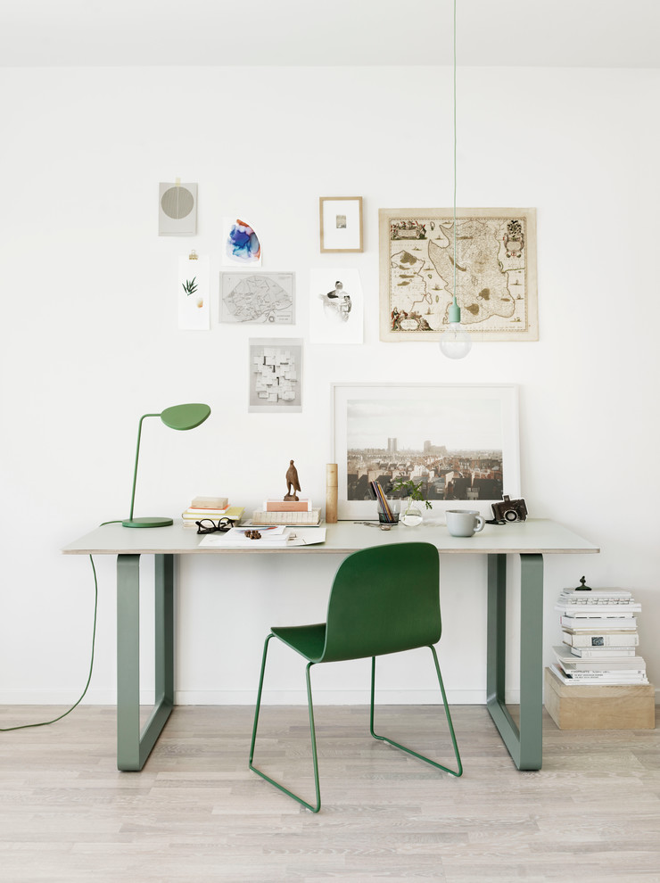 Mid-sized scandinavian home office in Copenhagen with white walls, a freestanding desk and light hardwood floors.
