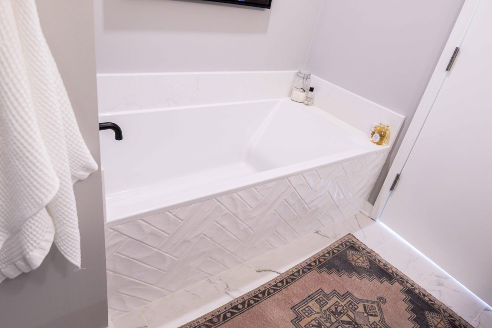 Esempio di una stanza da bagno padronale minimalista con vasca da incasso, piastrelle bianche, piastrelle in gres porcellanato, pareti grigie, pavimento con piastrelle in ceramica e pavimento bianco