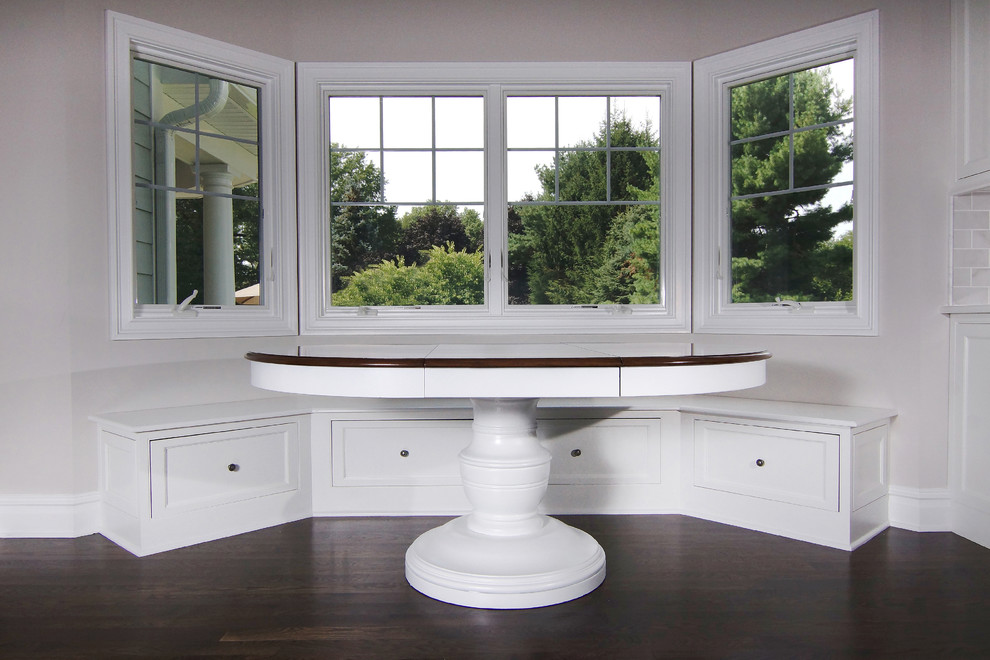 Example of a large transitional u-shaped dark wood floor eat-in kitchen design in New York with white cabinets, white backsplash, an island, a farmhouse sink, beaded inset cabinets, subway tile backsplash and paneled appliances