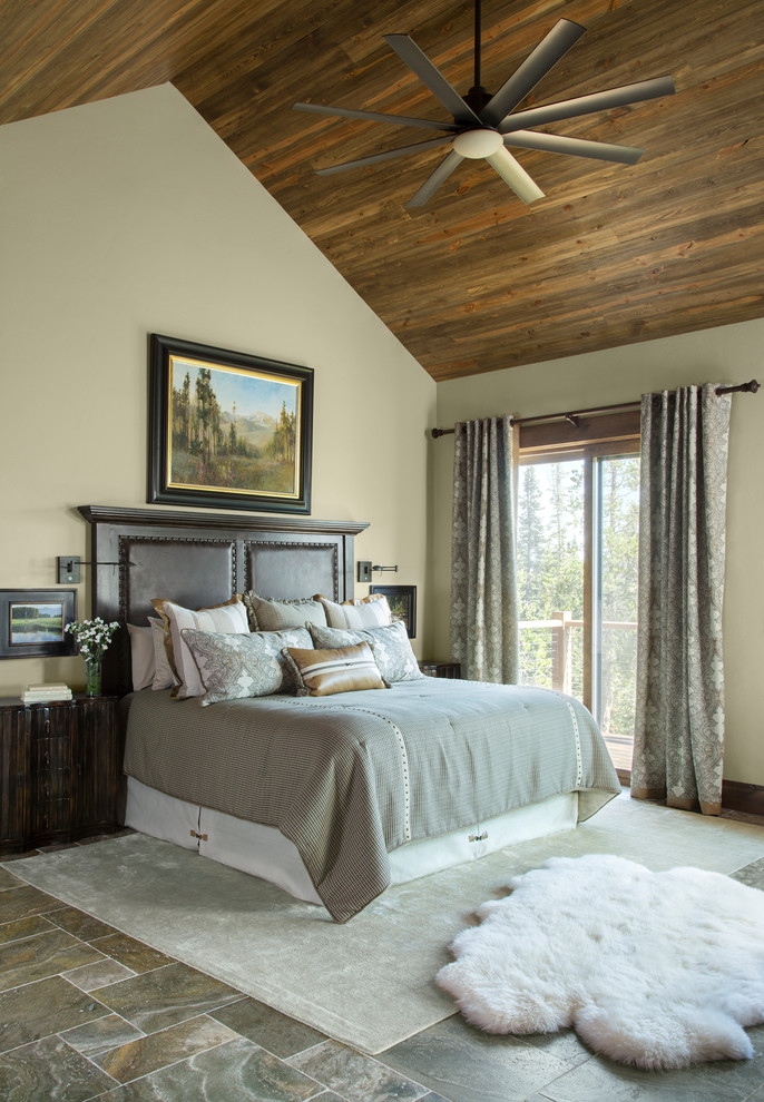 Inspiration for a mid-sized rustic master travertine floor and gray floor bedroom remodel in Denver with beige walls
