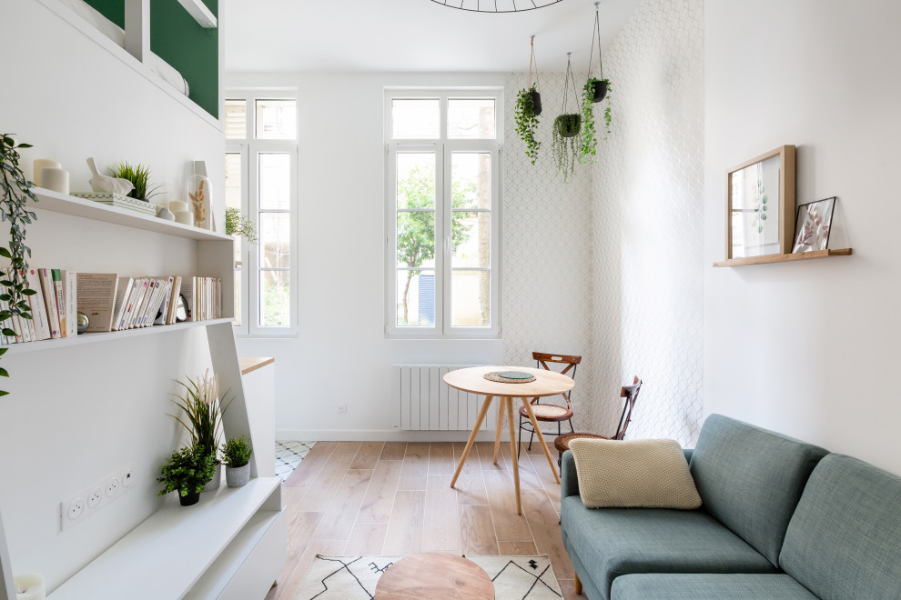 Diseño de biblioteca en casa abierta y blanca nórdica pequeña con paredes blancas, suelo de baldosas de cerámica, televisor independiente, suelo marrón y papel pintado