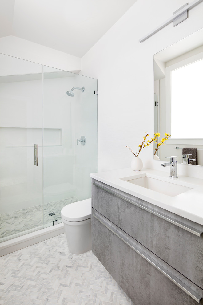 Design ideas for a small contemporary bathroom in DC Metro with flat-panel cabinets, grey cabinets, a corner shower, gray tile, porcelain tile, white walls, porcelain floors, an undermount sink and engineered quartz benchtops.