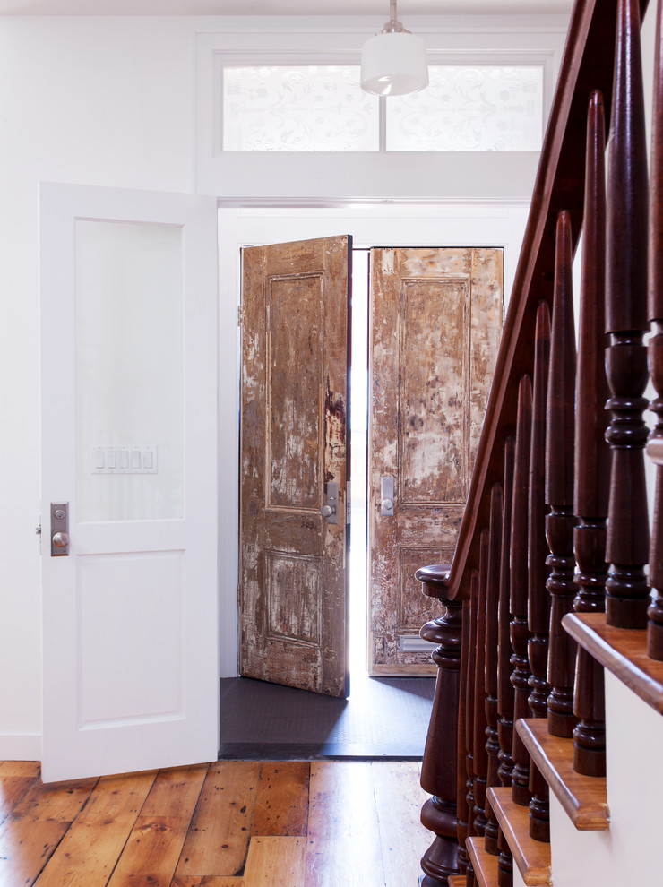 Mid-sized contemporary vestibule in New York with white walls, medium hardwood floors, a double front door and a medium wood front door.