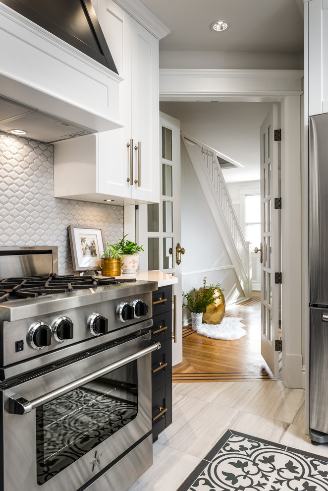 Eat-in kitchen - small transitional l-shaped porcelain tile and multicolored floor eat-in kitchen idea in Vancouver with an undermount sink, shaker cabinets, black cabinets, solid surface countertops, porcelain backsplash, stainless steel appliances, no island and gray backsplash