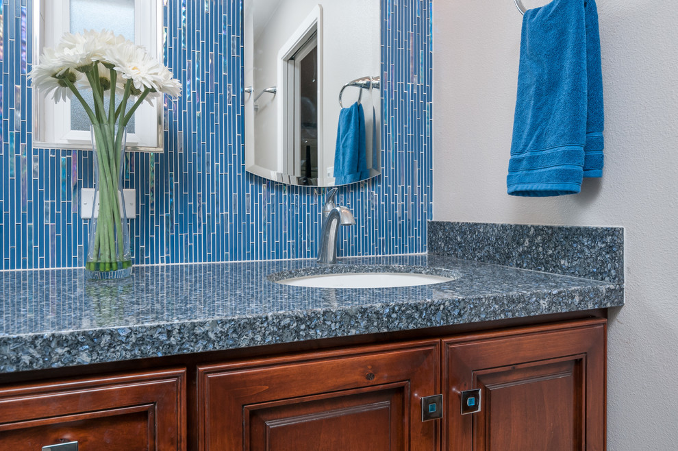 Design ideas for a small beach style master bathroom in San Francisco with an undermount sink, raised-panel cabinets, dark wood cabinets, engineered quartz benchtops, a corner shower, blue tile, glass tile, grey walls and porcelain floors.