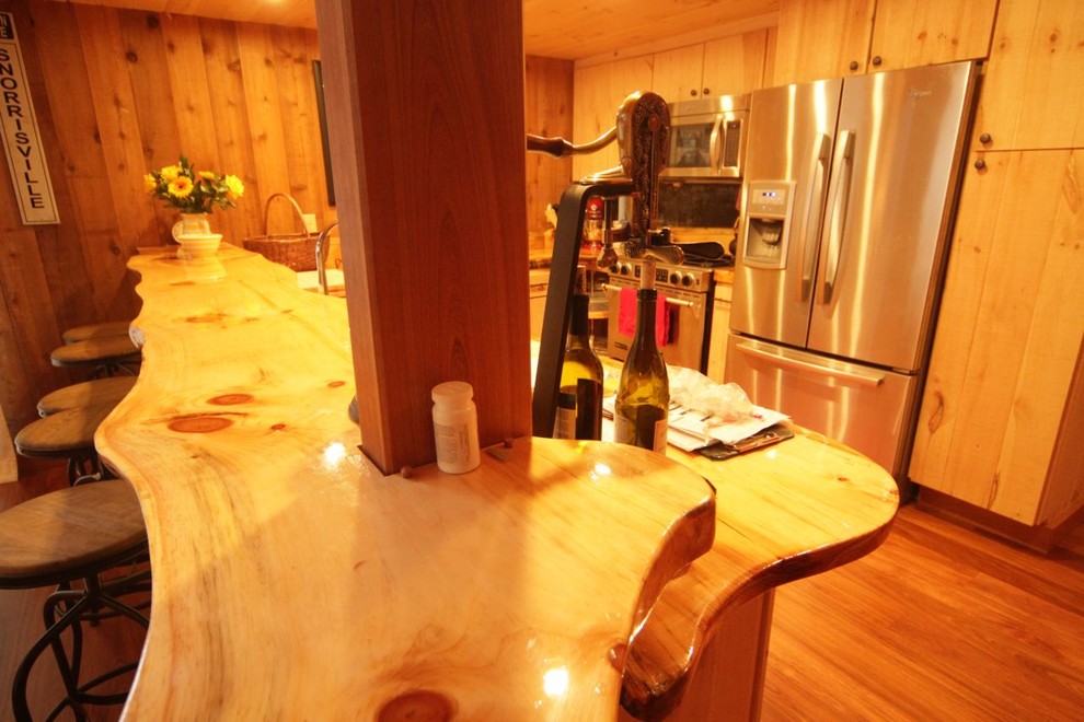Mid-sized mountain style u-shaped medium tone wood floor eat-in kitchen photo in Burlington with an undermount sink, flat-panel cabinets, light wood cabinets, wood countertops, metallic backsplash, metal backsplash, stainless steel appliances and a peninsula