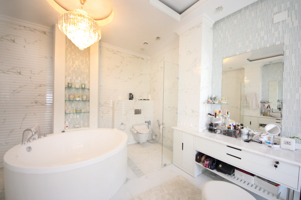 This is an example of a large eclectic bathroom in Moscow with flat-panel cabinets, white cabinets, a wall-mount toilet, white tile, porcelain tile, white walls, ceramic floors, a vessel sink, marble benchtops, white floor, white benchtops, a freestanding vanity, recessed and panelled walls.