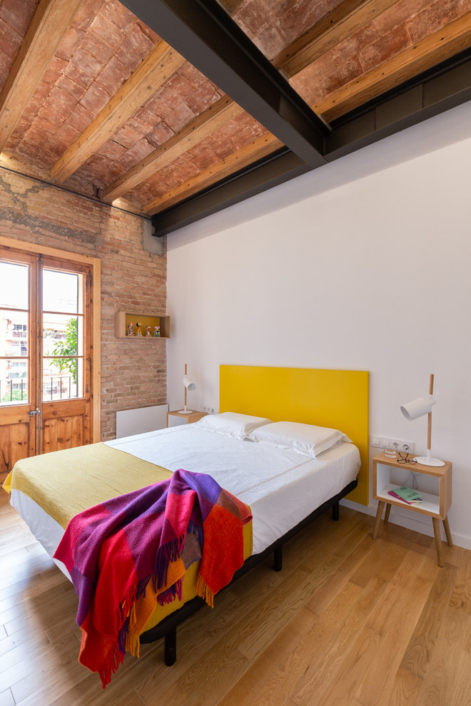 Photo of a mid-sized mediterranean master bedroom in Barcelona with white walls, light hardwood floors and brown floor.