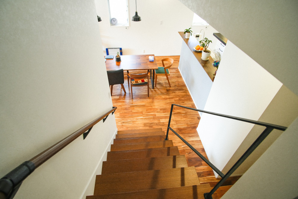 Aménagement d'un escalier moderne en L de taille moyenne avec des marches en bois, des contremarches en bois, un garde-corps en matériaux mixtes et du papier peint.