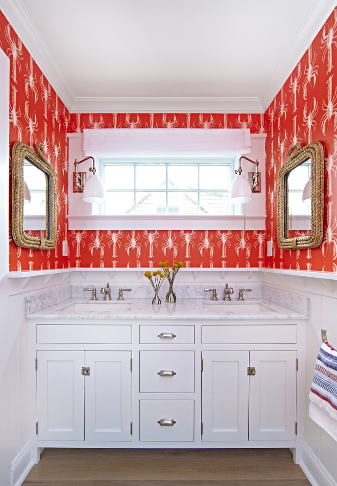 Design ideas for a large beach style kids bathroom in New York with shaker cabinets, white cabinets, a freestanding tub, a shower/bathtub combo, a two-piece toilet, red walls, light hardwood floors, an undermount sink and marble benchtops.