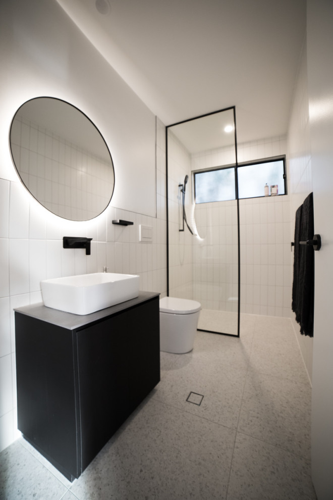 Свежая идея для дизайна: маленькая главная ванная комната в стиле лофт с черными фасадами, открытым душем, унитазом-моноблоком, белой плиткой, удлиненной плиткой, белыми стенами, полом из керамической плитки, настольной раковиной, столешницей из ламината, белым полом, открытым душем, белой столешницей, тумбой под одну раковину и встроенной тумбой для на участке и в саду - отличное фото интерьера
