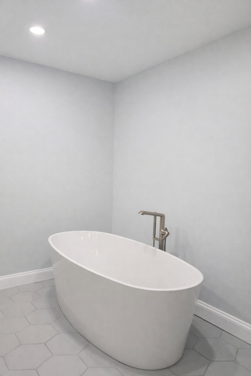 Stand alone tub with new floor mounted faucet system in modern white.