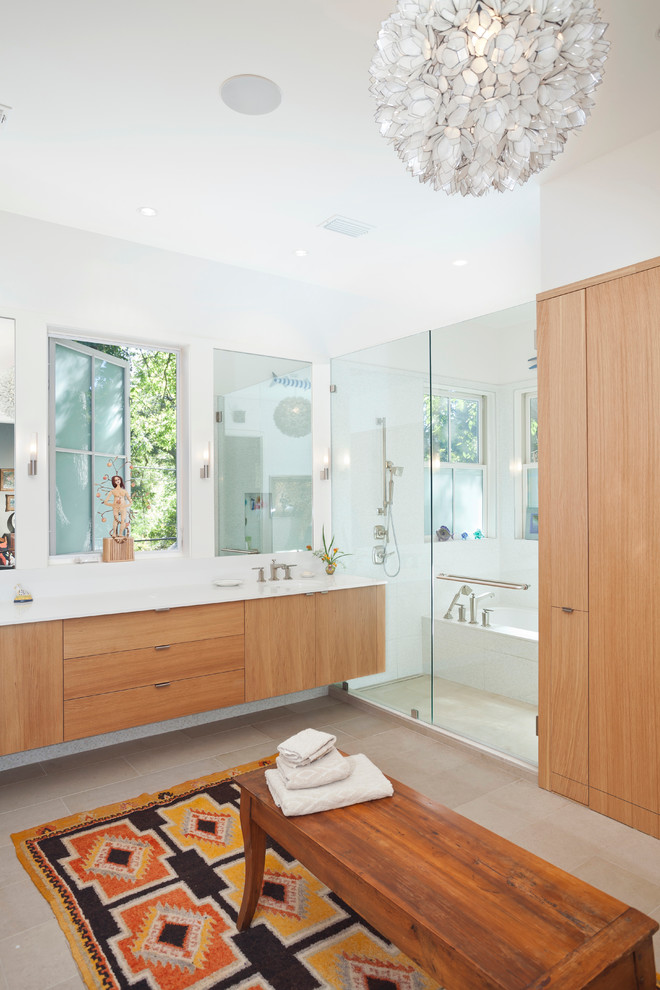 Large contemporary master bathroom in Austin with an undermount sink, flat-panel cabinets, medium wood cabinets, engineered quartz benchtops, an alcove tub, a shower/bathtub combo, a one-piece toilet, white tile, ceramic tile, limestone floors, white walls, beige floor and a hinged shower door.