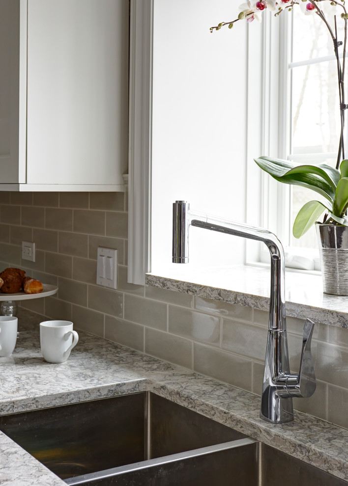 Open concept kitchen - large transitional u-shaped medium tone wood floor open concept kitchen idea in Chicago with a double-bowl sink, flat-panel cabinets, white cabinets, quartz countertops, beige backsplash, subway tile backsplash, stainless steel appliances and an island