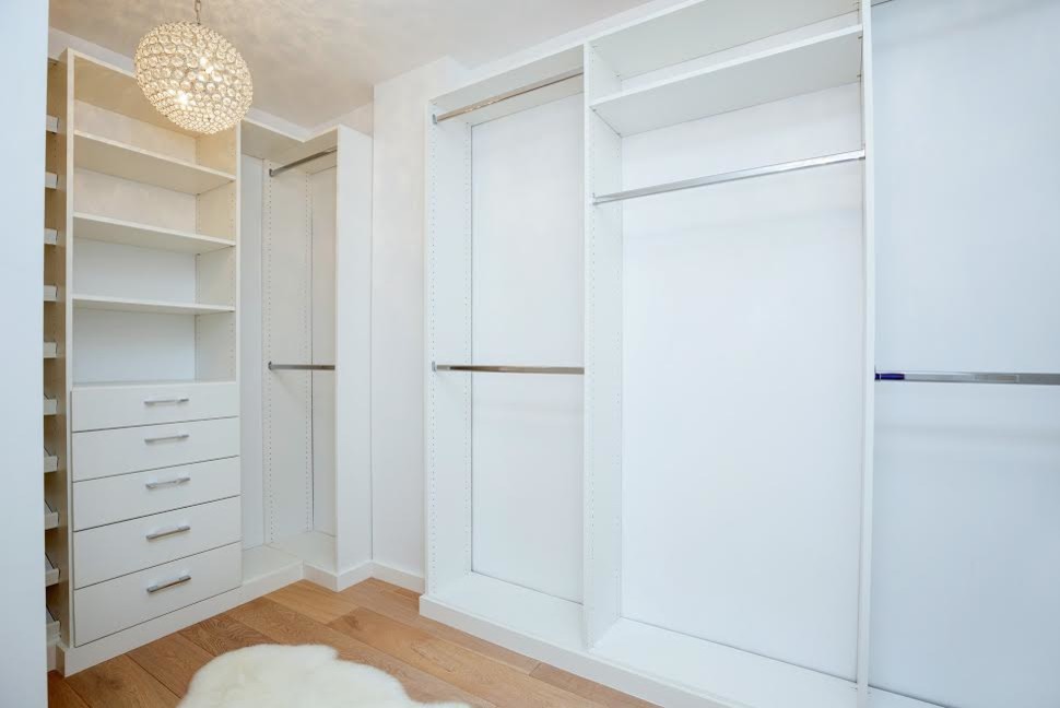 Inspiration for a large contemporary walk-in wardrobe in Los Angeles with open cabinets, white cabinets and medium hardwood floors.