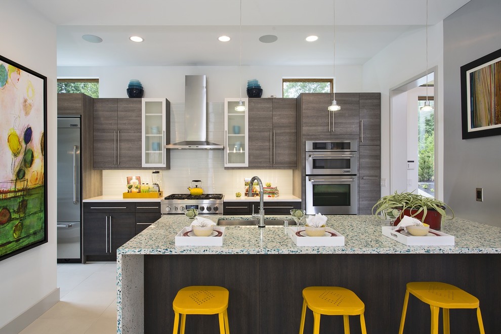 This is an example of a contemporary galley kitchen in Seattle with an undermount sink, flat-panel cabinets, grey cabinets, white splashback, glass tile splashback, stainless steel appliances and multi-coloured benchtop.