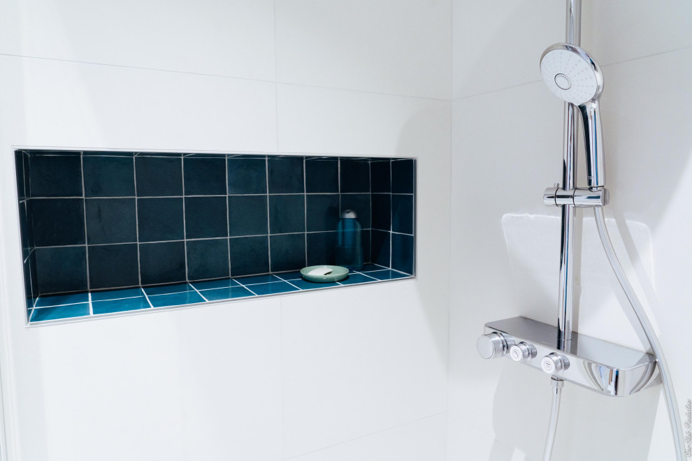 Пример оригинального дизайна: главная ванная комната среднего размера в скандинавском стиле с синими фасадами, душем без бортиков, биде, белой плиткой, керамической плиткой, синими стенами, полом из керамической плитки, раковиной с пьедесталом, мраморной столешницей, белым полом, душем с раздвижными дверями, белой столешницей, нишей и тумбой под одну раковину