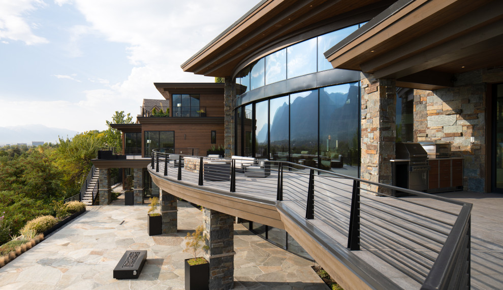 Diseño de terraza de estilo zen grande en patio trasero y anexo de casas con brasero y barandilla de metal