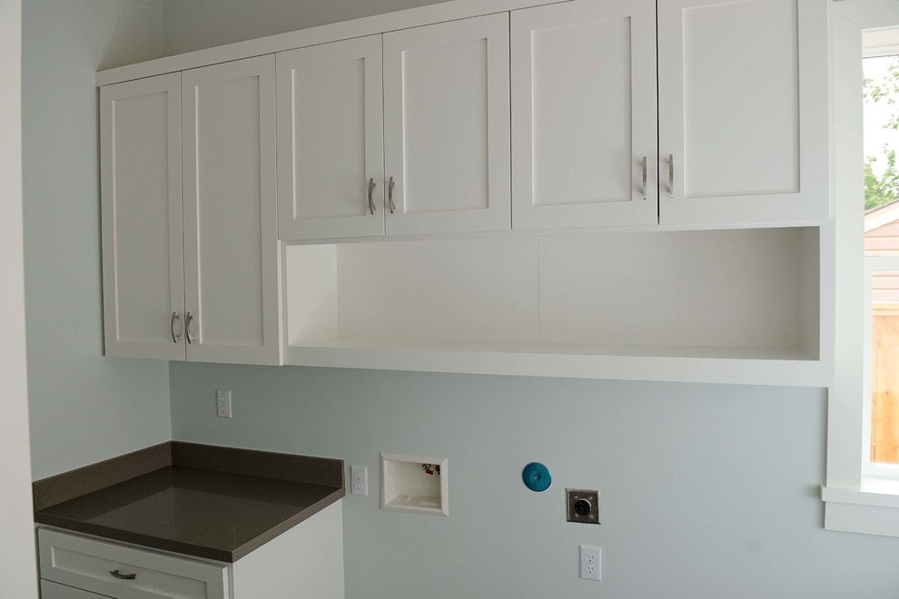 Mid-sized l-shaped dedicated laundry room in Houston with an undermount sink, flat-panel cabinets, white cabinets, grey walls, slate floors and a side-by-side washer and dryer.