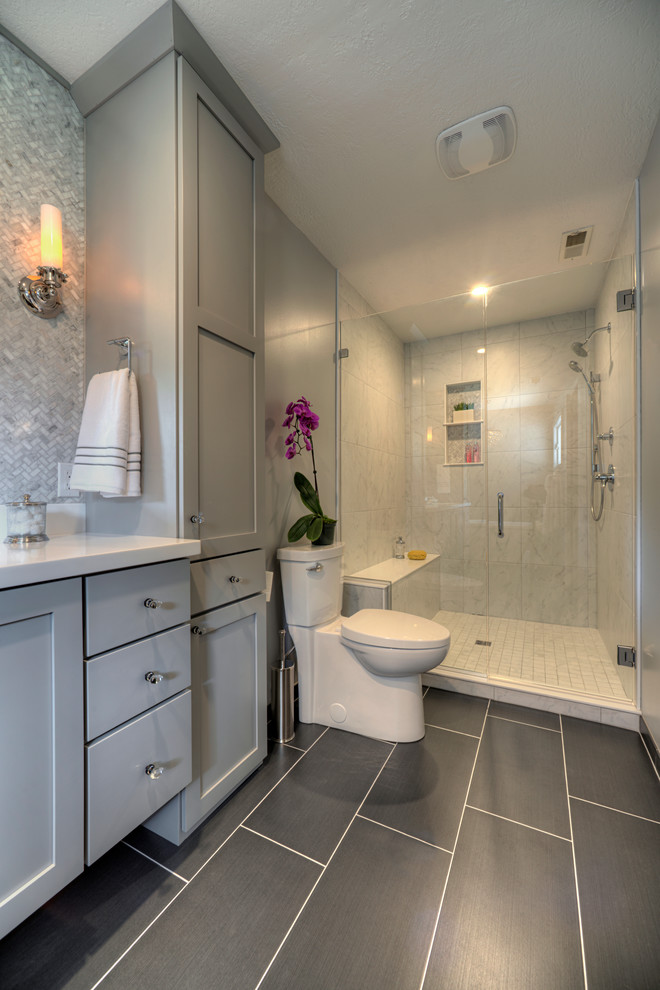 Inspiration for a transitional bathroom in Chicago with shaker cabinets, grey cabinets, an alcove shower, a two-piece toilet, white tile, grey walls and black floor.