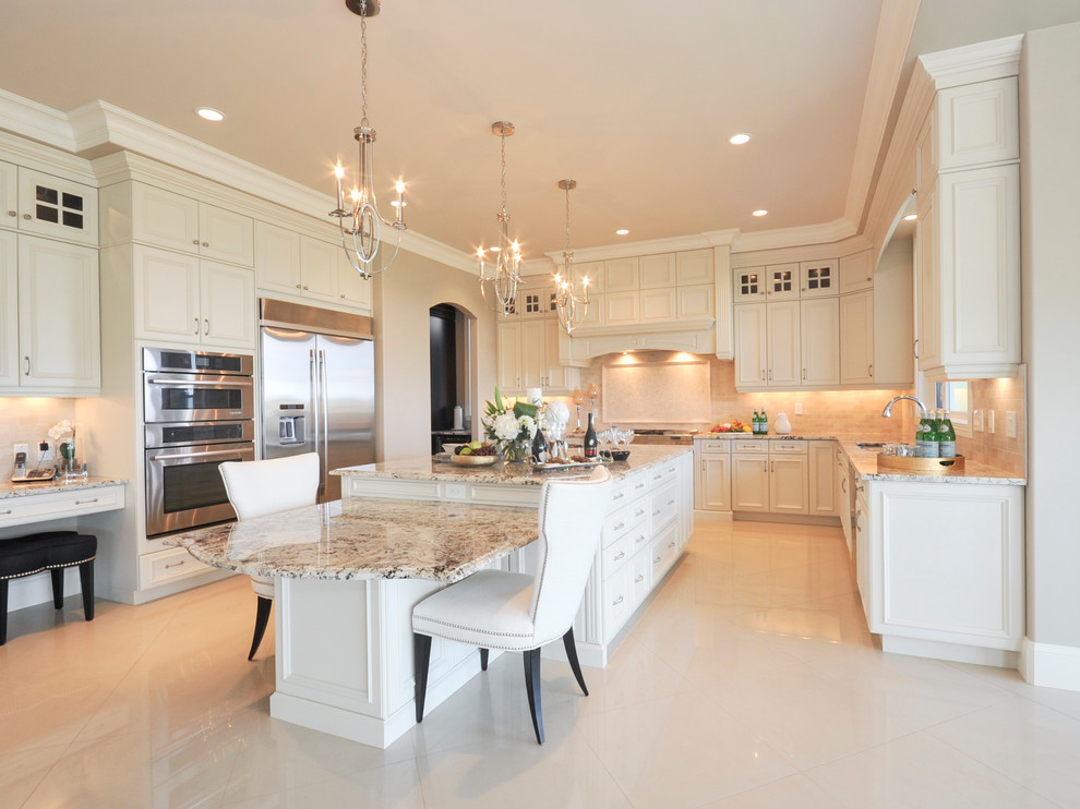 Photo of a large traditional u-shaped open plan kitchen in Edmonton with an undermount sink, recessed-panel cabinets, white cabinets, granite benchtops, beige splashback, stone tile splashback, stainless steel appliances, marble floors and with island.
