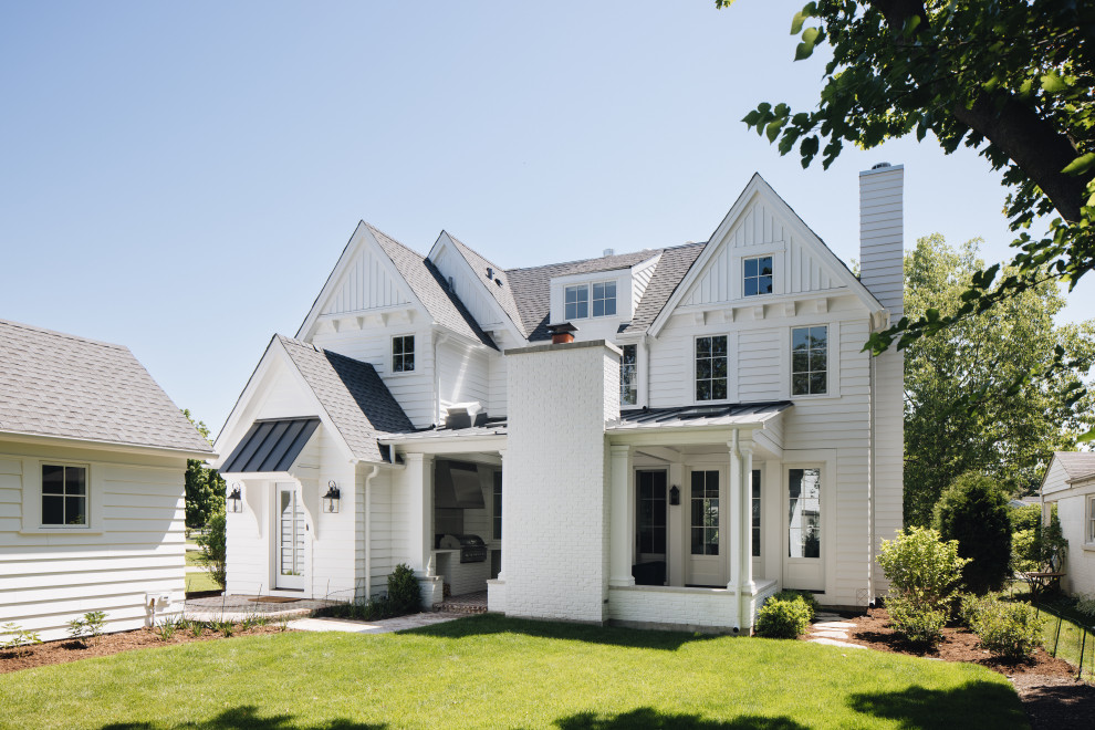 Immagine della villa bianca country a due piani di medie dimensioni con tetto a capanna, copertura a scandole, tetto grigio e con scandole