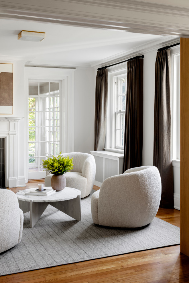На фото: изолированная гостиная комната среднего размера в стиле неоклассика (современная классика) с белыми стенами, паркетным полом среднего тона, стандартным камином и фасадом камина из плитки с