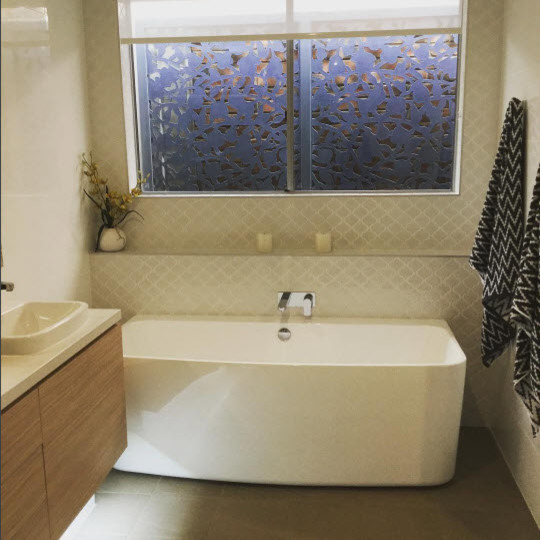 Mid-sized modern 3/4 bathroom in Adelaide with furniture-like cabinets, medium wood cabinets, a freestanding tub, brown tile, porcelain tile, grey walls, porcelain floors and engineered quartz benchtops.