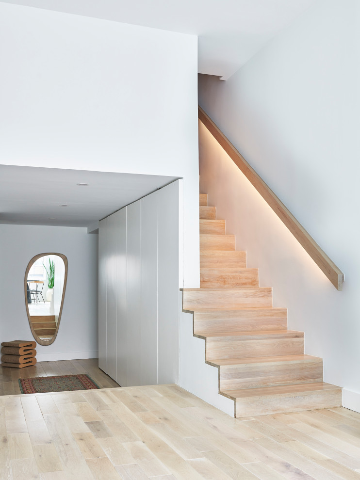 Photo of a small modern wood straight staircase in New York with wood risers and wood railing.
