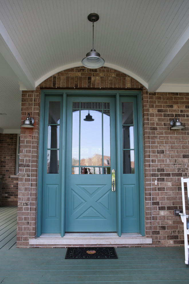 This is an example of a large country entryway in Chicago with painted wood floors and a green front door.