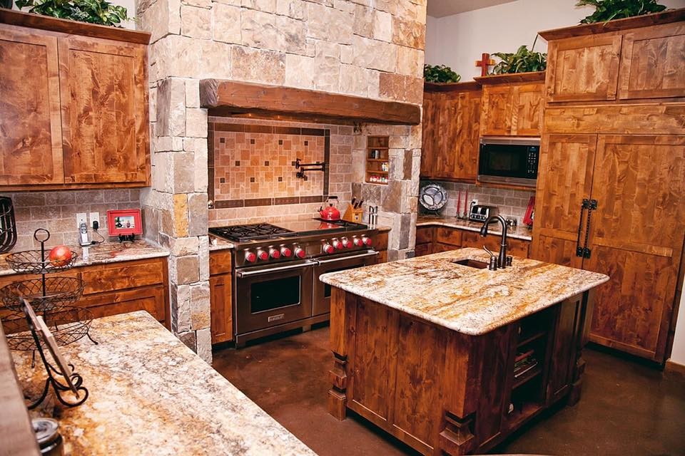Inspiration for a mid-sized rustic l-shaped concrete floor and brown floor open concept kitchen remodel in Austin with a farmhouse sink, shaker cabinets, dark wood cabinets, granite countertops, gray backsplash, ceramic backsplash, stainless steel appliances, two islands and brown countertops