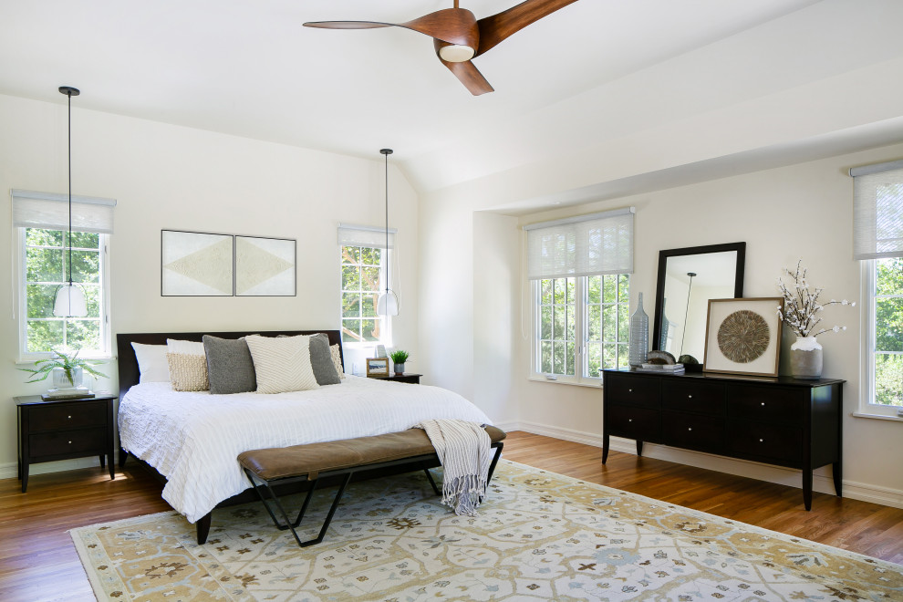 Design ideas for a transitional bedroom in Los Angeles with white walls, medium hardwood floors and brown floor.