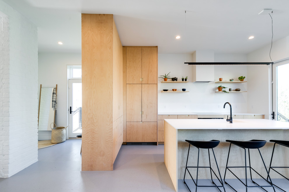 Mid-sized modern eat-in kitchen in Richmond with an integrated sink, flat-panel cabinets, light wood cabinets, light hardwood floors, with island and white benchtop.