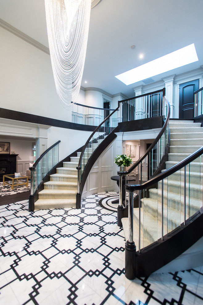 Expansive traditional carpeted curved staircase in Vancouver with painted wood risers.