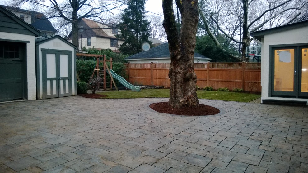 Mid-sized traditional backyard patio in New York with natural stone pavers and no cover.