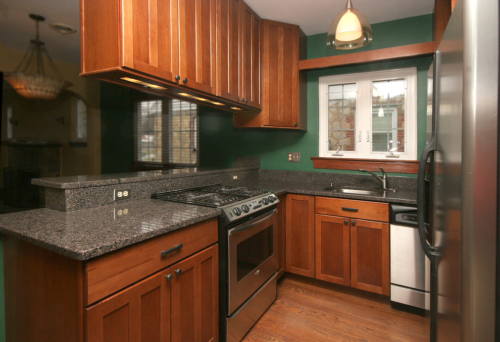 Mid-sized traditional galley eat-in kitchen in DC Metro with an undermount sink, medium wood cabinets, granite benchtops, medium hardwood floors, stainless steel appliances and recessed-panel cabinets.