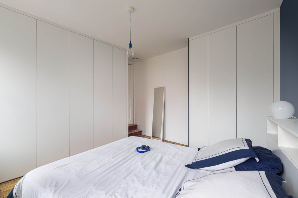 Dressing?[Cette image montre dressing With un placard à porte plane and parquet clair.]:[Cette image montre dressings With un placard à porte plane and parquet clair.]