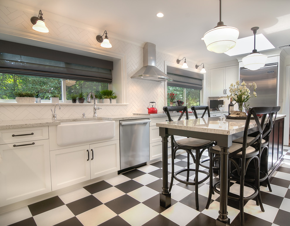 Transitional u-shaped multicolored floor enclosed kitchen photo with a farmhouse sink, recessed-panel cabinets, white cabinets, granite countertops, white backsplash, subway tile backsplash, stainless steel appliances, an island and beige countertops