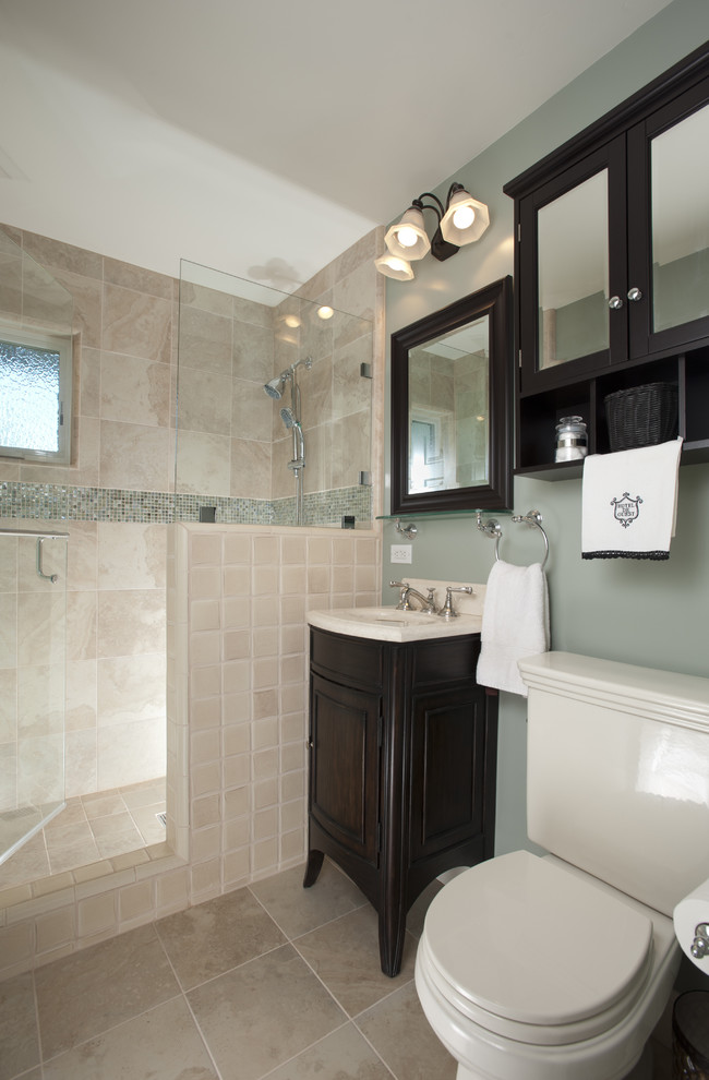 Mid-sized traditional 3/4 bathroom in San Francisco with a pedestal sink, furniture-like cabinets, dark wood cabinets, a two-piece toilet, marble benchtops, porcelain tile, beige tile, an alcove shower, grey walls, travertine floors, beige floor, a hinged shower door, beige benchtops, a niche, a single vanity and a freestanding vanity.