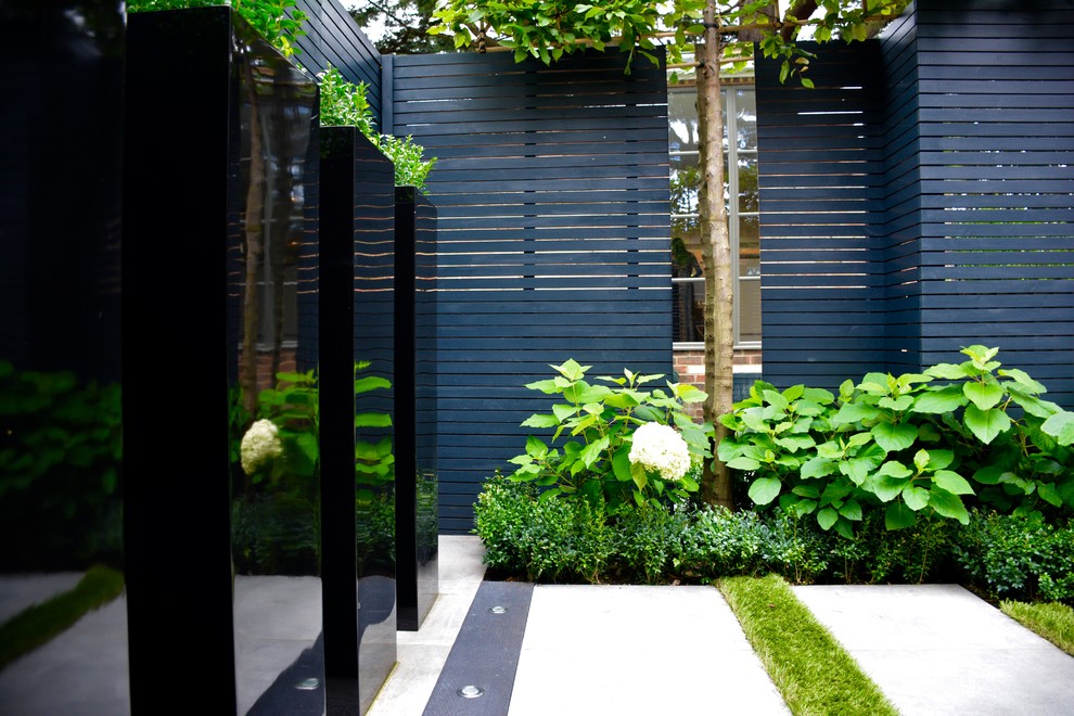 Design ideas for a small contemporary courtyard partial sun garden in London with concrete paving.
