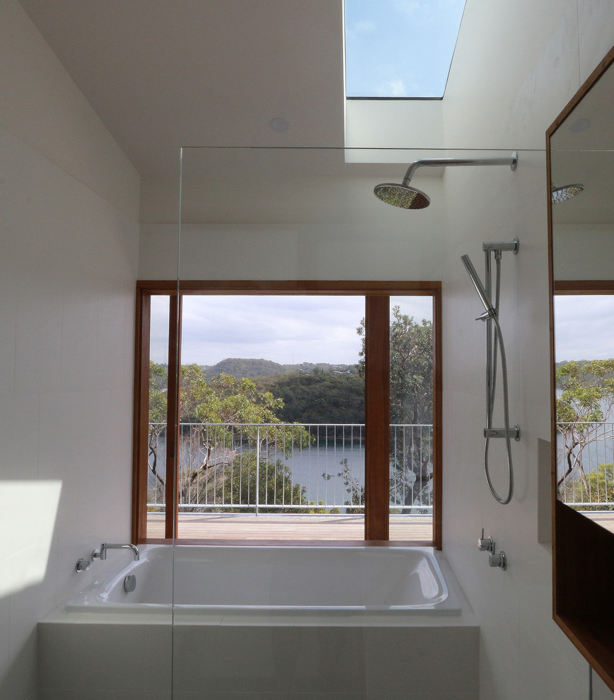 Mid-sized contemporary master bathroom with flat-panel cabinets, dark wood cabinets, a drop-in tub, an open shower, white tile, ceramic tile, engineered quartz benchtops and white benchtops.