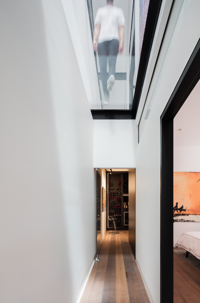 Photo of a contemporary hallway in Sydney with white walls and medium hardwood floors.