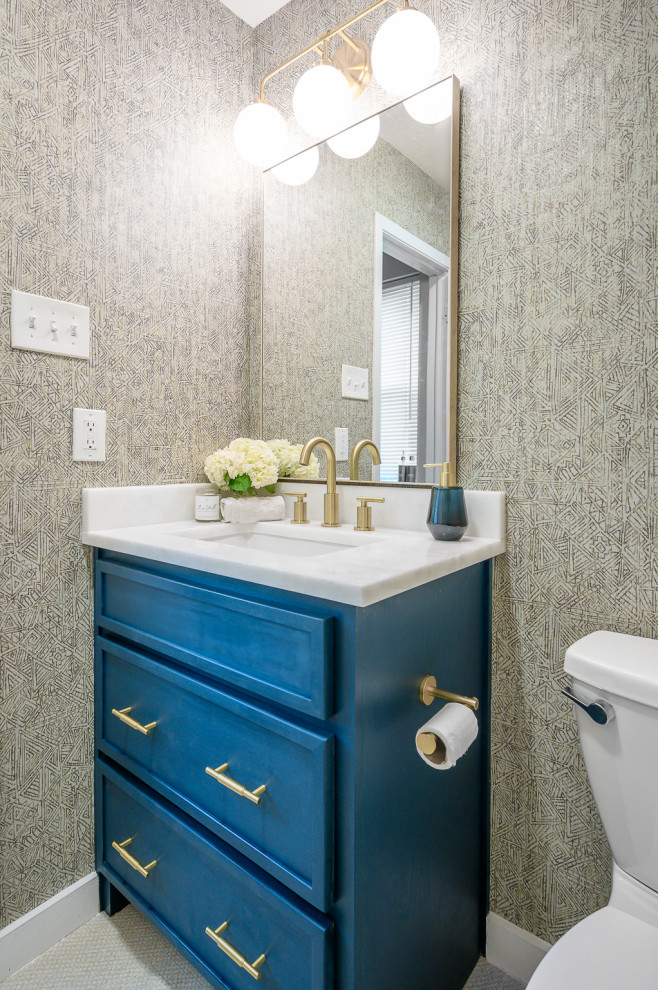 Inspiration for a small transitional porcelain tile, beige floor and wallpaper powder room remodel in Dallas with shaker cabinets, blue cabinets, a two-piece toilet, multicolored walls, an undermount sink, marble countertops, white countertops and a built-in vanity