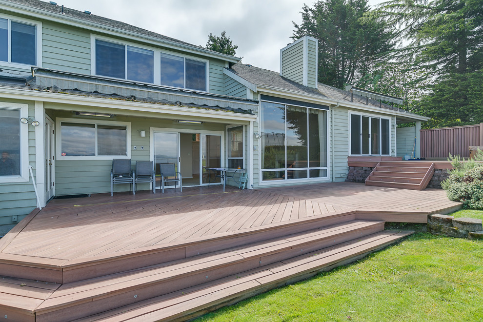 This is an example of a contemporary two-storey green exterior in Seattle with mixed siding and a shingle roof.