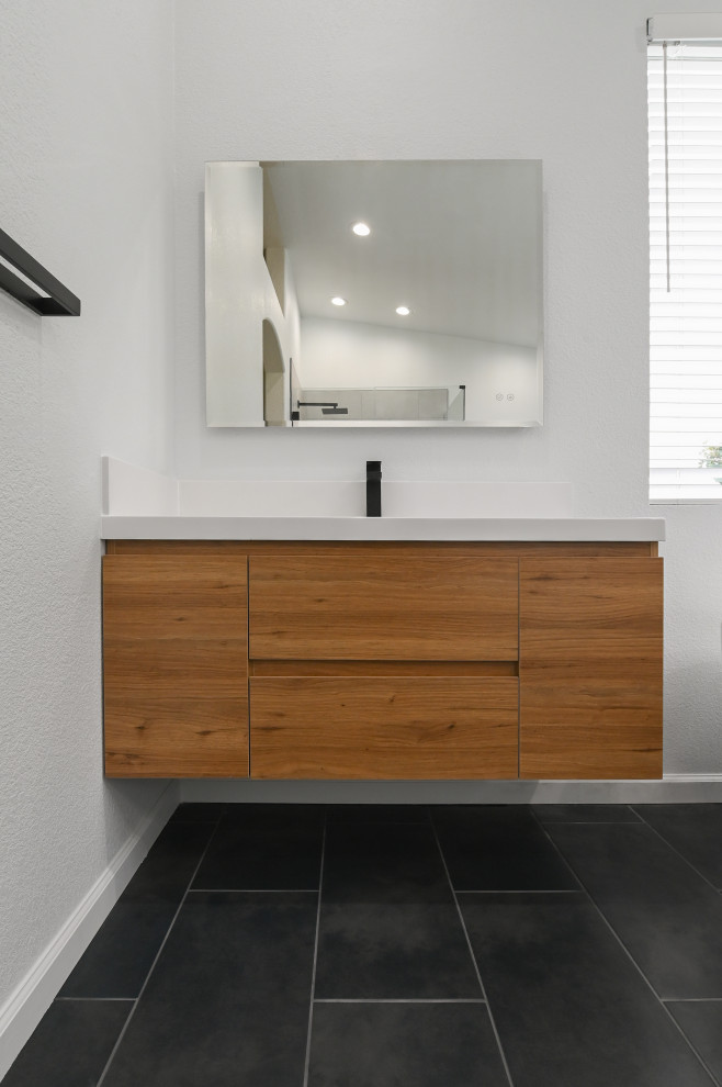 Idée de décoration pour une salle de bain minimaliste en bois clair avec un placard à porte plane, un lavabo intégré, un plan de toilette en marbre, un plan de toilette blanc, meuble simple vasque et meuble-lavabo suspendu.