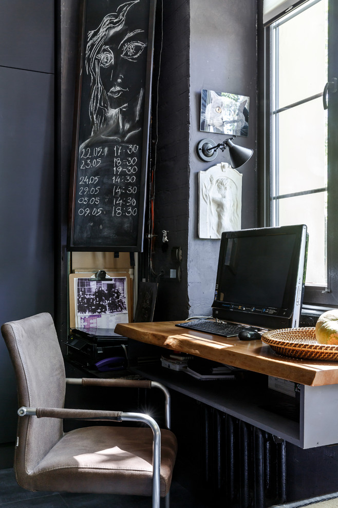 This is an example of an industrial study room with black walls and a built-in desk.