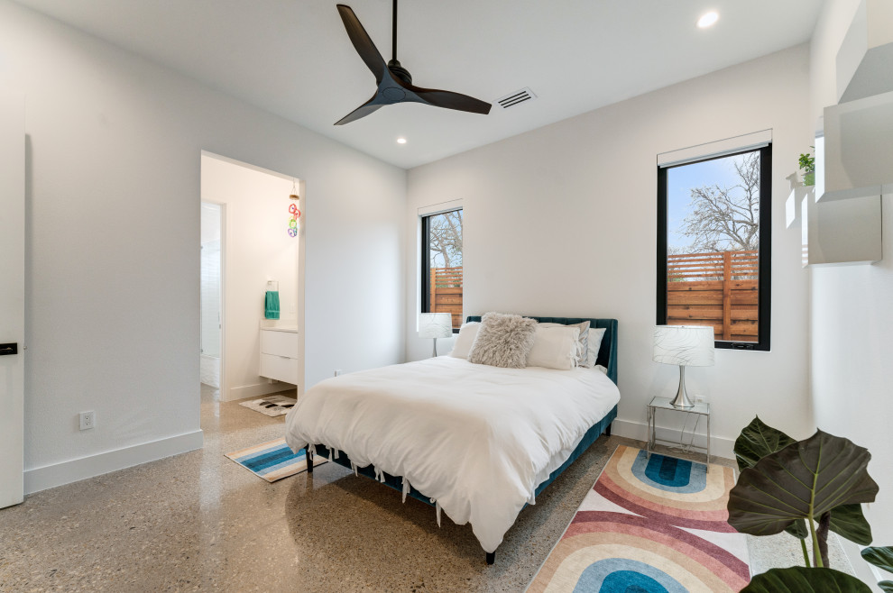 На фото: гостевая спальня (комната для гостей) в современном стиле с белыми стенами, бетонным полом и серым полом
