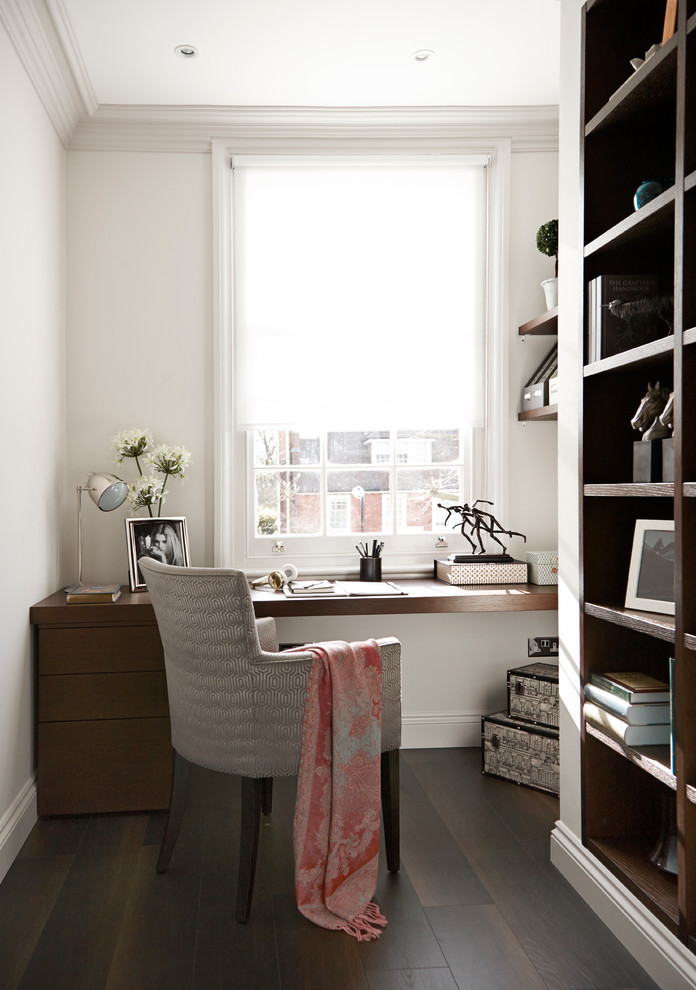 Inspiration for a contemporary home office in London with dark hardwood floors, a built-in desk and white walls.